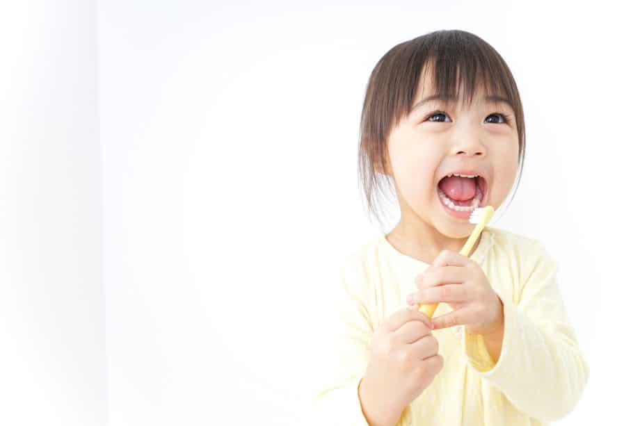 little girl holding toothbrush