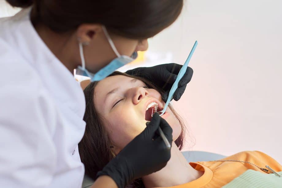 dentist looking inside woman's mouth